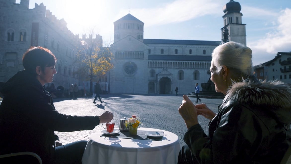 Cinzia Angelini와 그녀의 어머니가 이탈리아 트렌토 도심 광장에서 차를 마시고 있습니다.