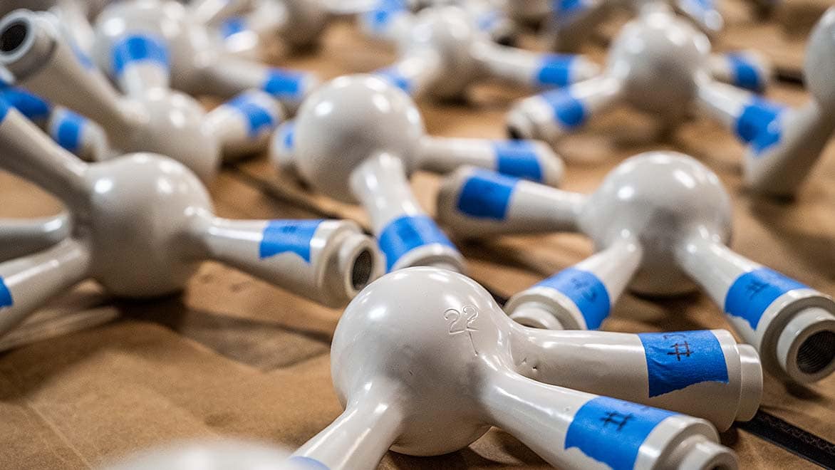 White plastic objects with blue pieces of tape with numbers written on them