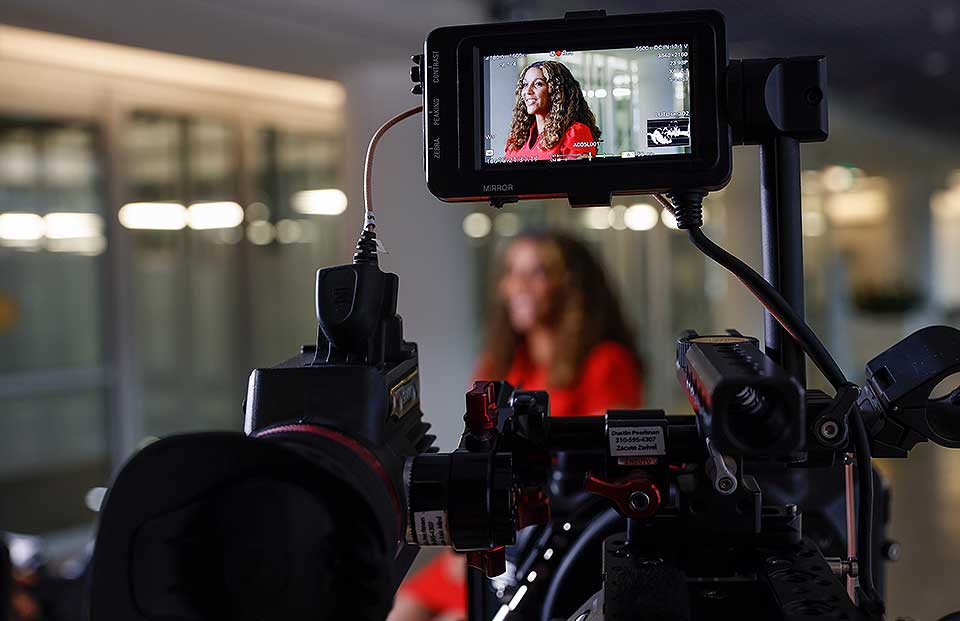 A woman being filmed using a camera.