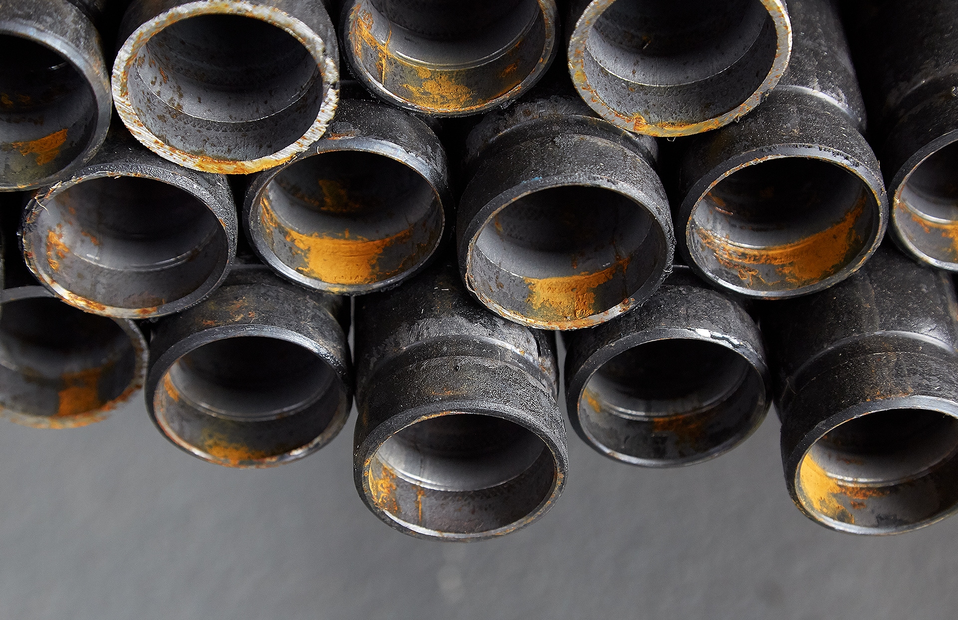 Closeup of the ends of a collection of thick steel pipes