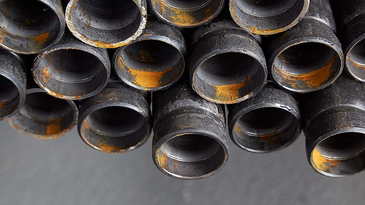 Closeup of the ends of a collection of thick steel pipes 