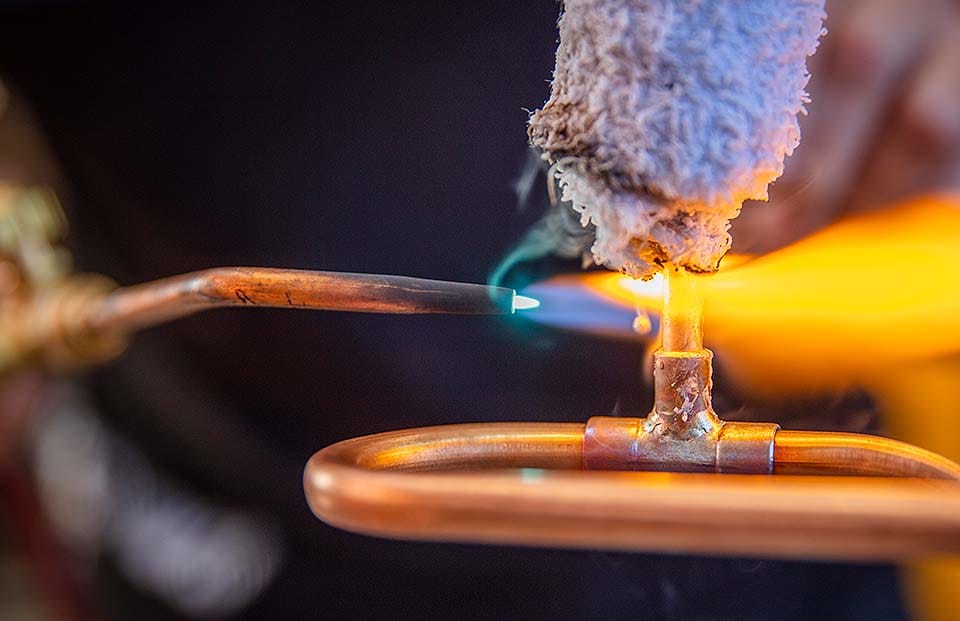 Closeup of copper joints being soldered
