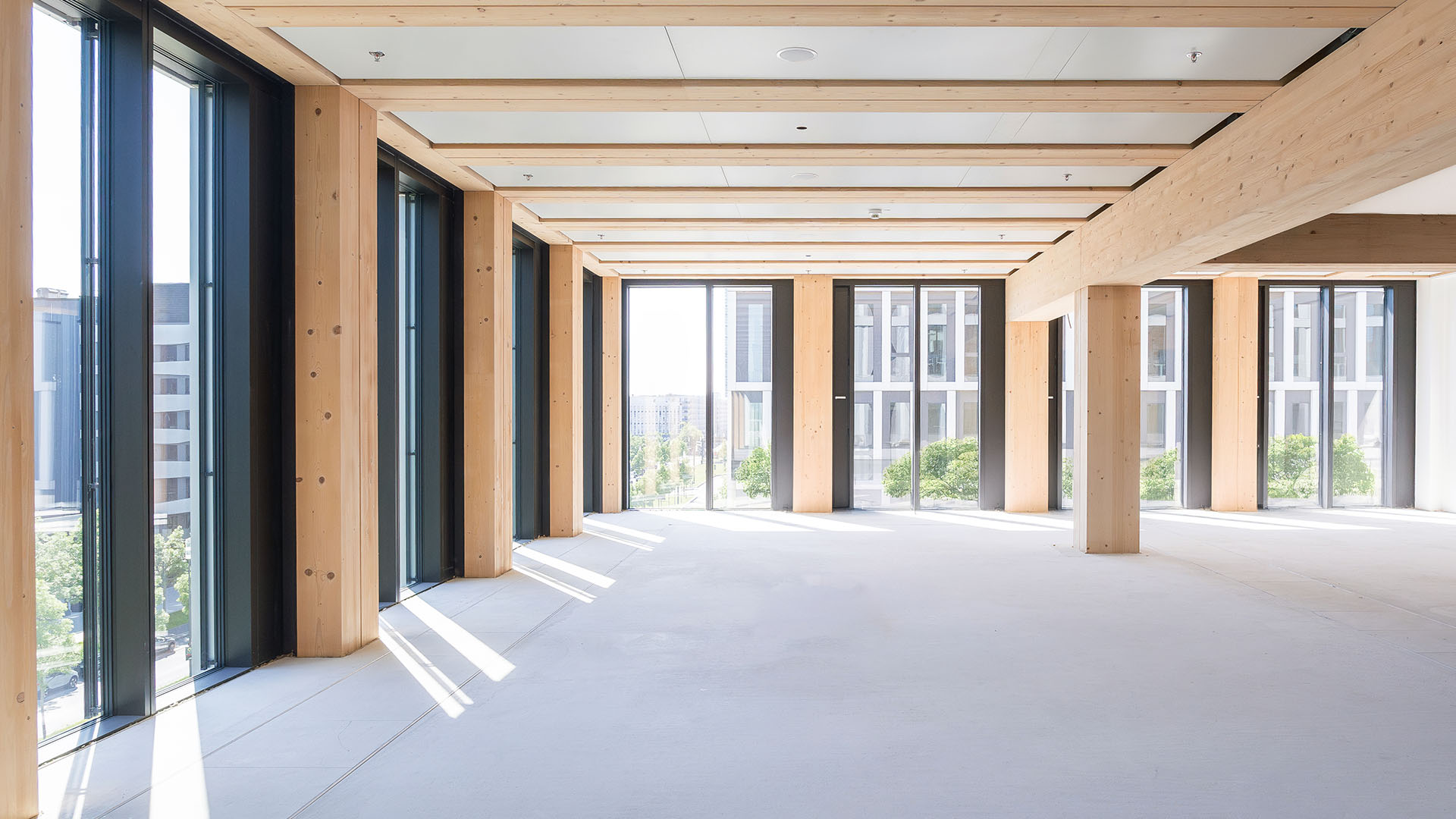 Office space featuring exposed wood, steel, and tall windows. 