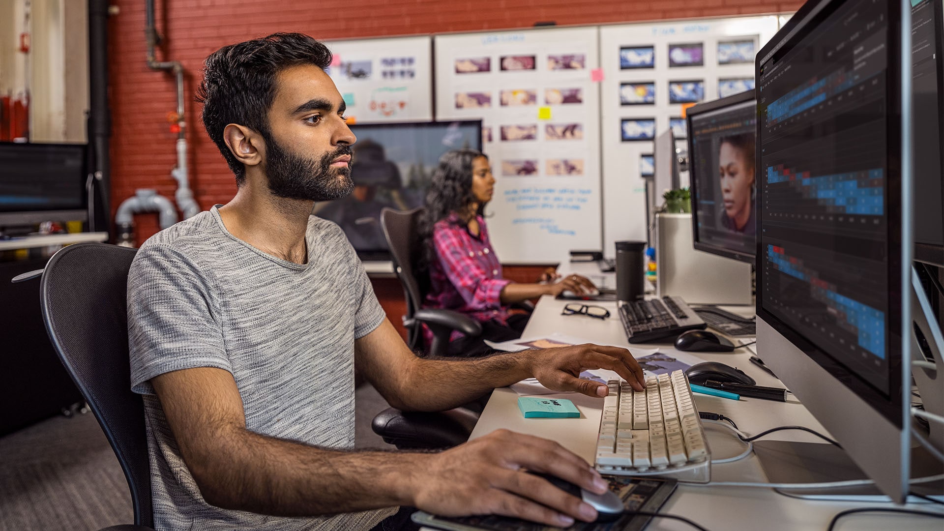 Man works at computer station in an office. 