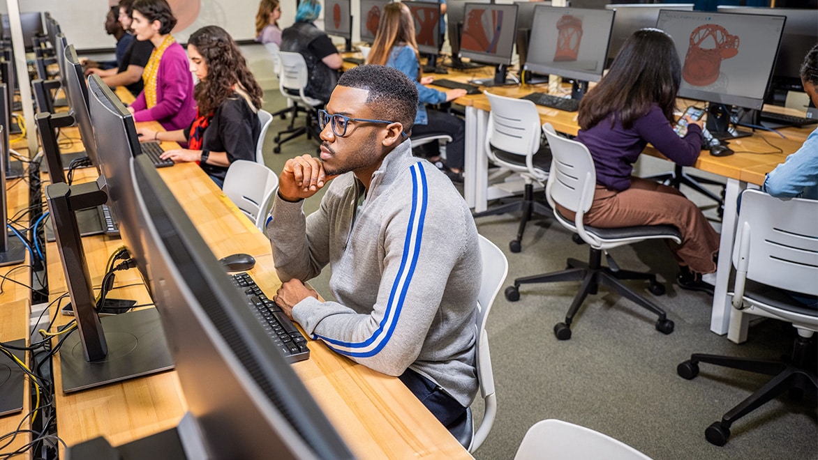 Students sit at computers in a computer lab