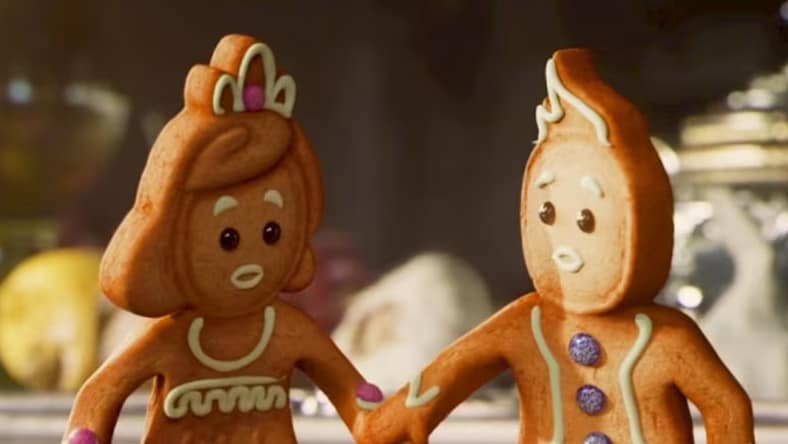 Two gingerbread characters decorated with icing and candy details, standing side by side.