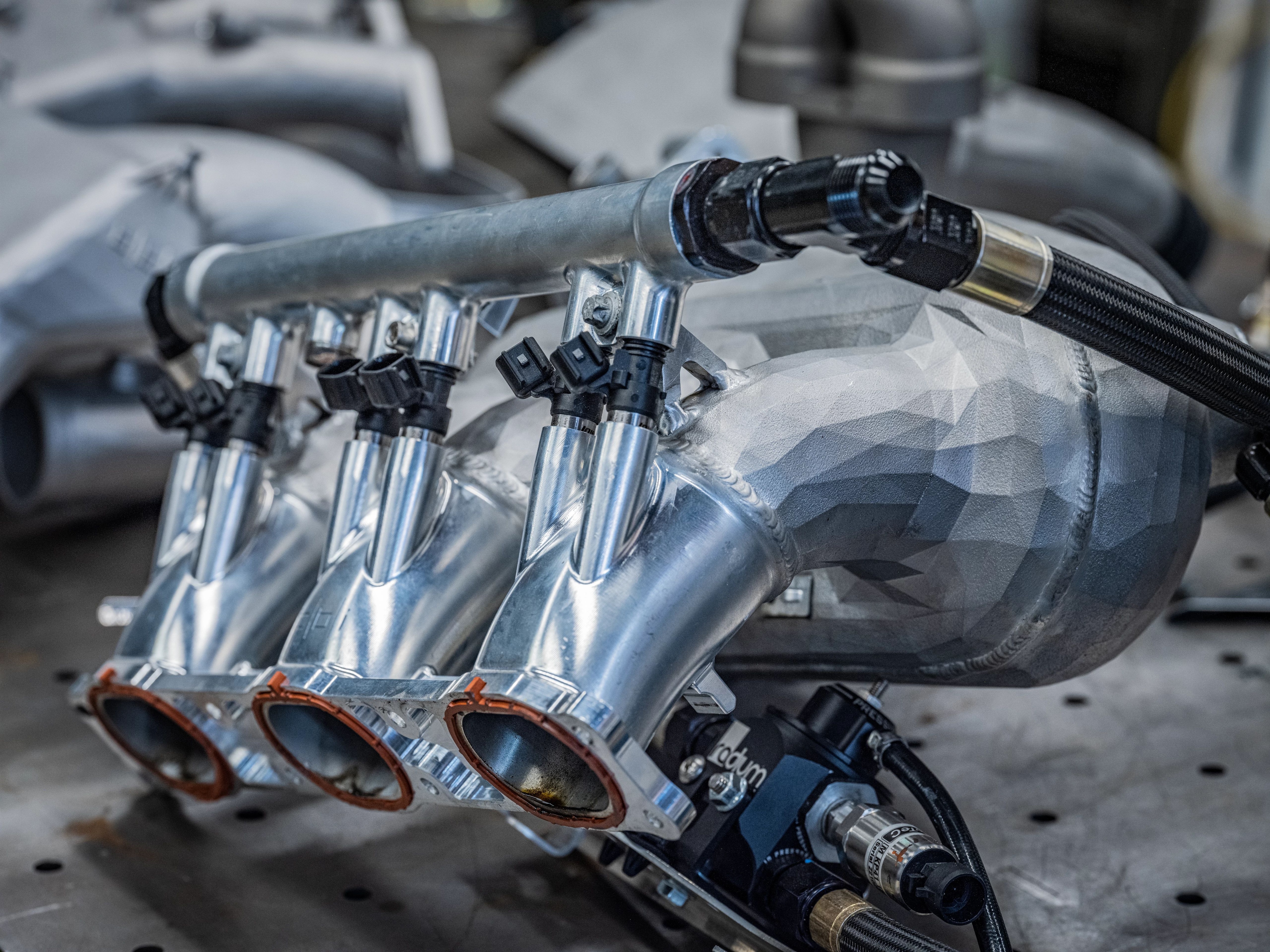 A close-up of a custom-made metal automobile engine part.