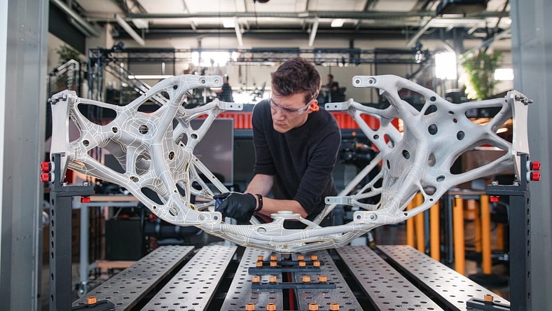 An engineer works on a 3D-printed prototype of a concept space lander.
