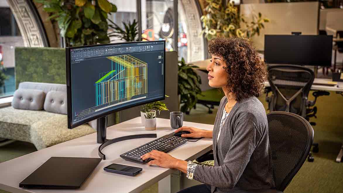 Woman using AutoCAD in an office environment.