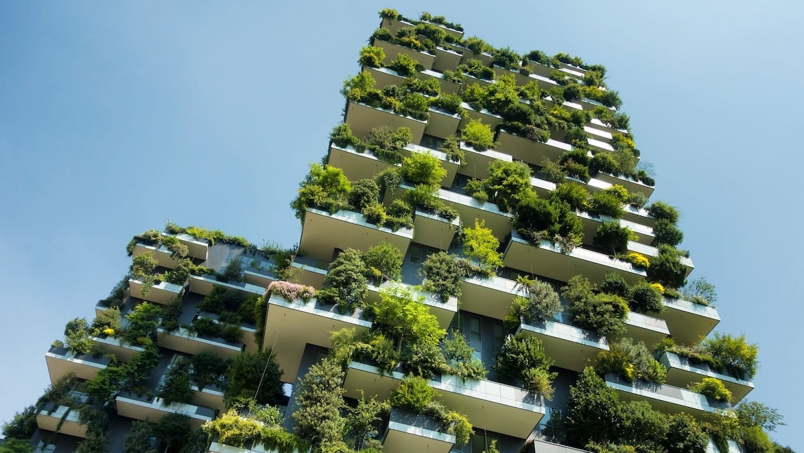 Trees fill every balcony in a high-rise apartment building.