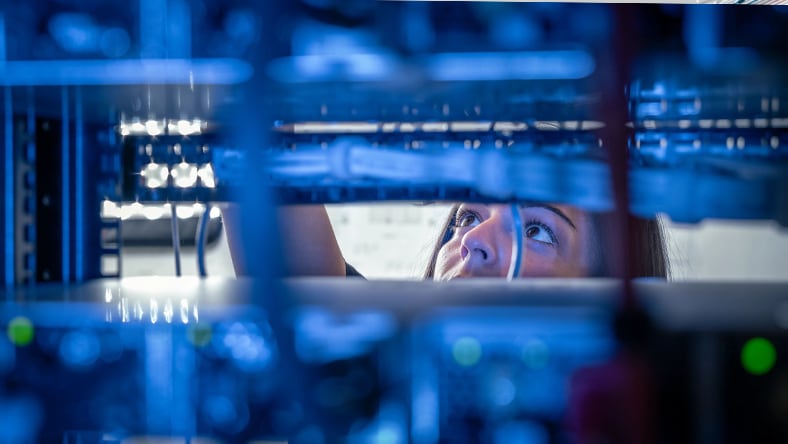 Engineer looking at cords and servers