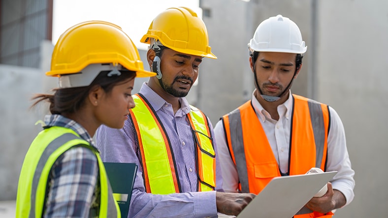 Site workers looking at building design on a screen