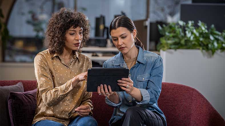 Women collaborating and viewing a tablet.