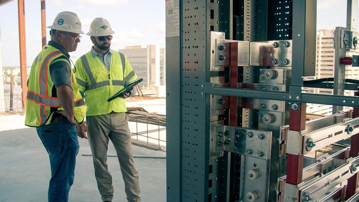 Engineers reviewing structural components in construction site.