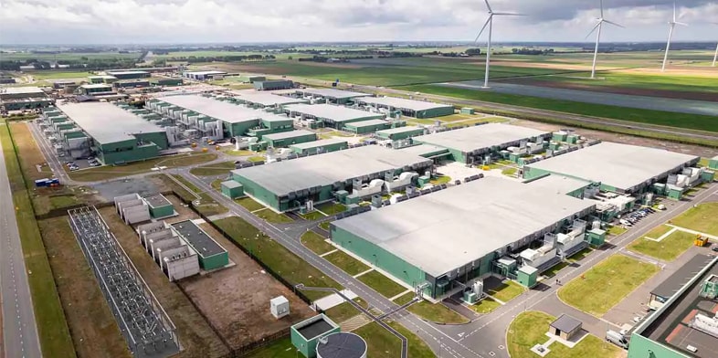 A large data center is located next to windmills.