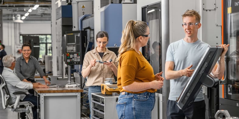 A group of Autodesk employees talking in the Technology Center.