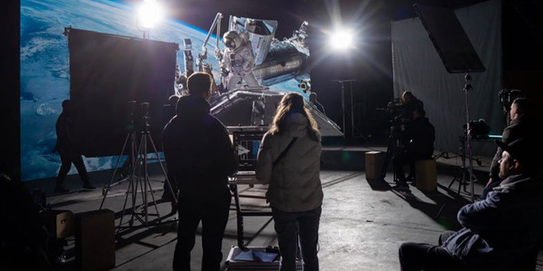 A movie set with a production crew watching a scene. 