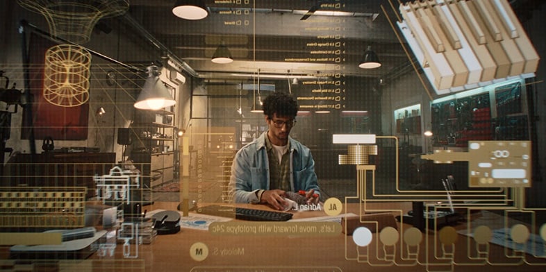 A small business designer at his computer designing keyboards. 