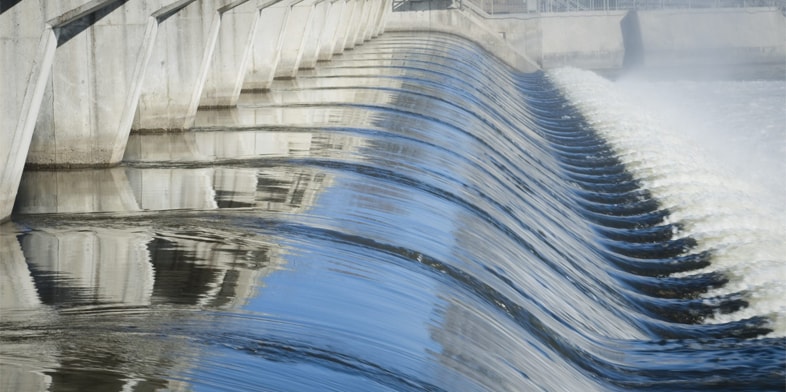 A side view of water infrastructure showing water flowing through concrete channels. 