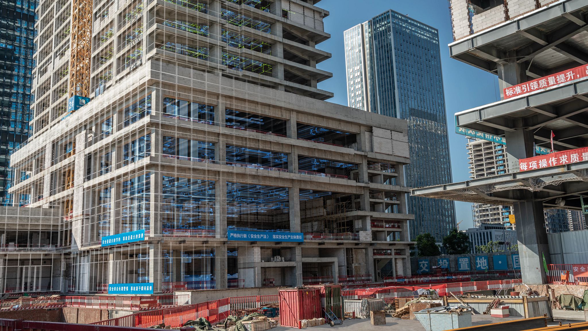 High-rise construction site with exposed concrete and steel structures.