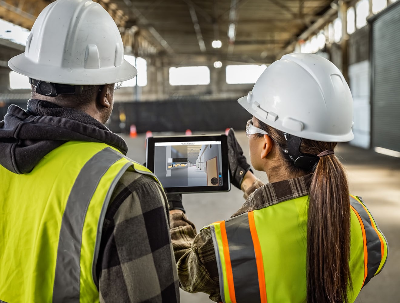 Workers viewing a digital tablet at a construction site.