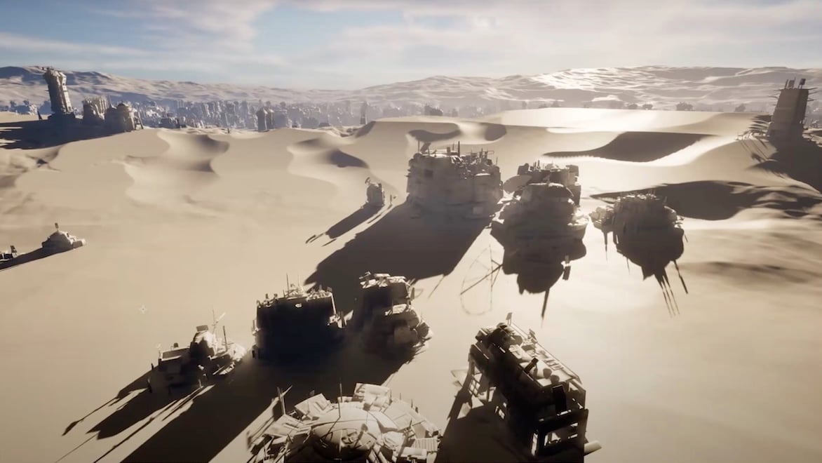 Armored vehicles and structures cast long shadows on sand dunes with a city in the background.