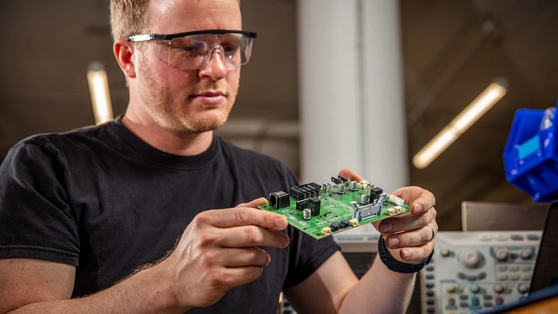 A man holds a printed circuit board.