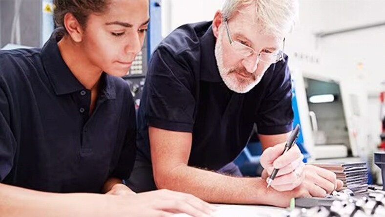 Two people look at a design