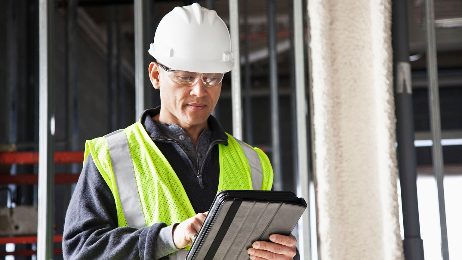 Construction worker using tablet for project management.