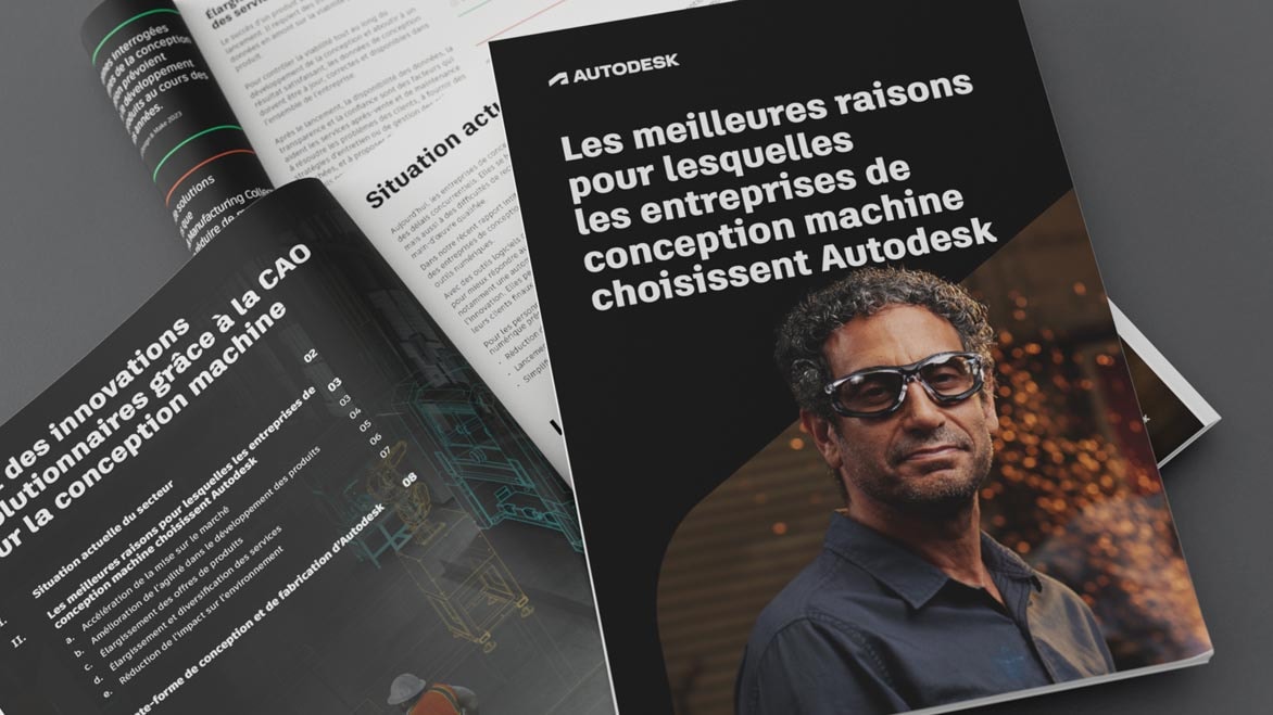 Un concepteur et un ingénieur qui se tiennent debout dans un atelier et observent le schéma d’un modèle de CAO machine 