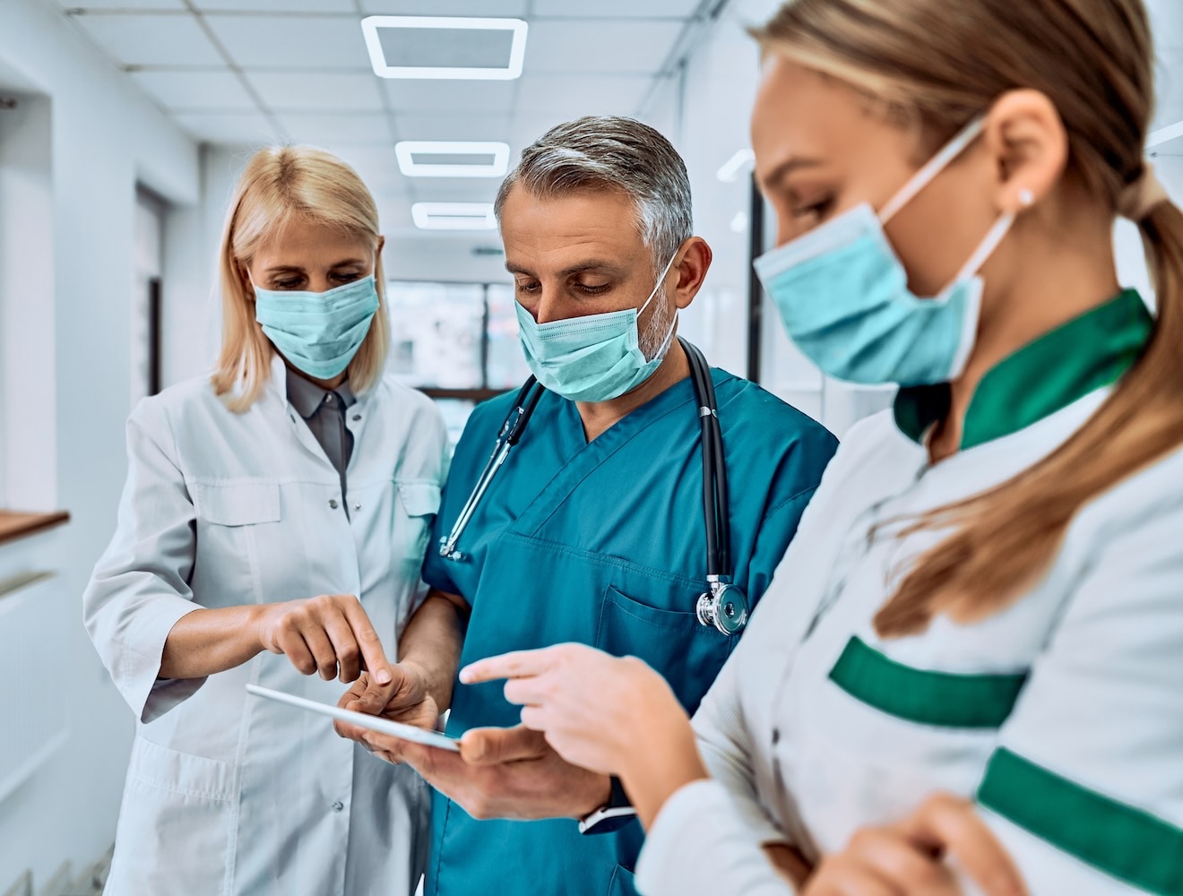 Doctors and nurses review patient data on an iPad.