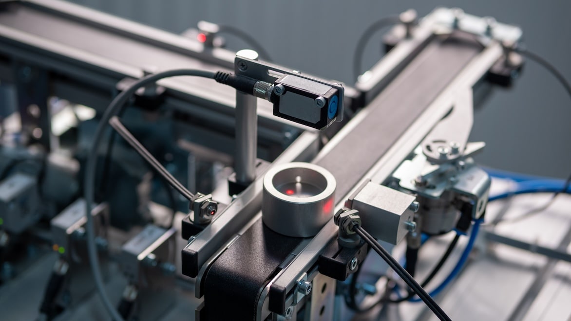 1202739653 Close-up of a product on an IIoT factory assembly line equipped with sensors.