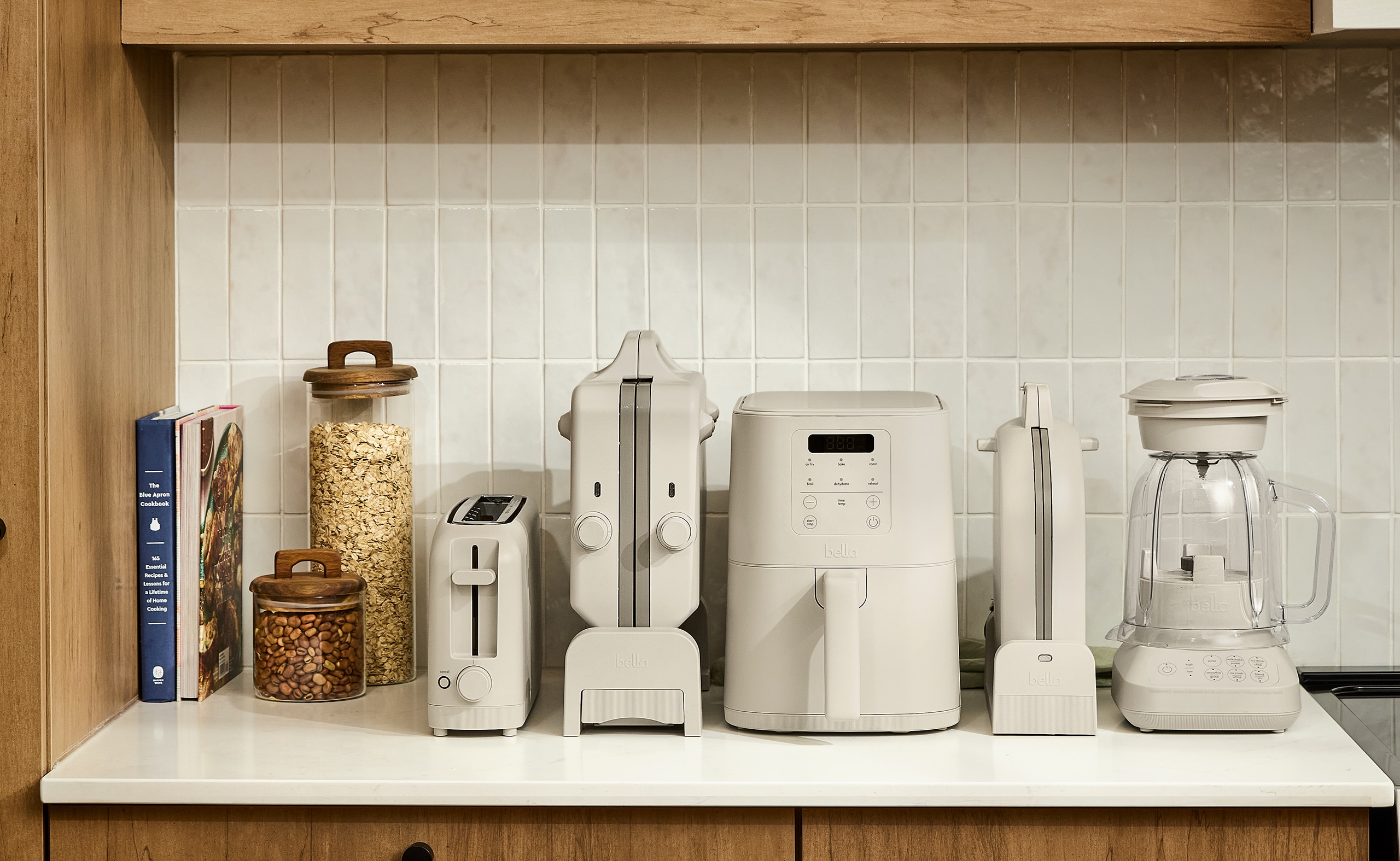 kitchen counter with various appliances, including a toaster, waffle maker, air fryer, and blender. 