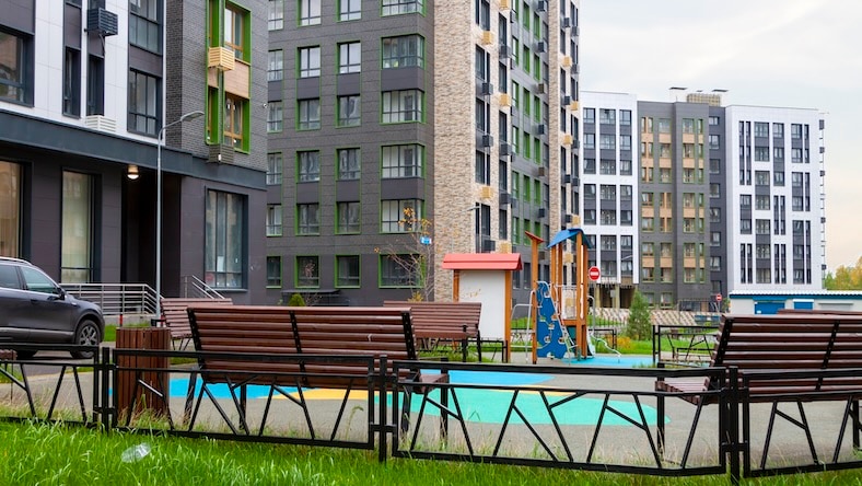 A large urban building complex features mixed-use residential and commercial spaces.