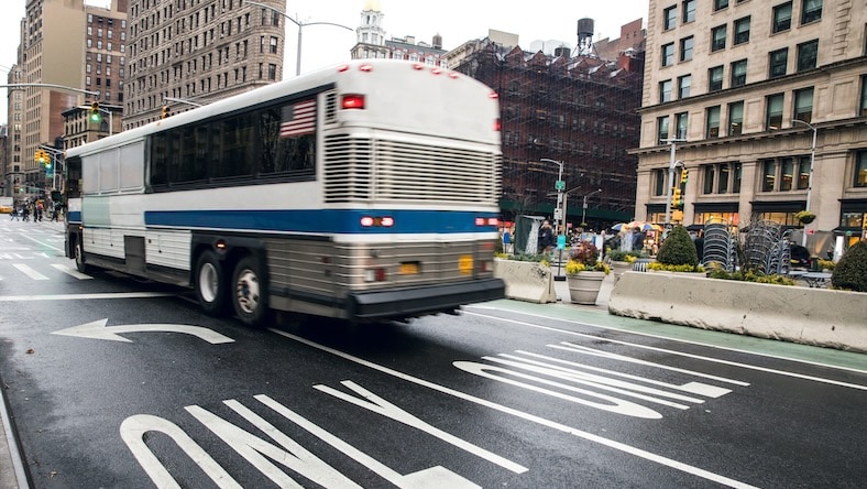 A bus travels along a dedicated street lane in a city.