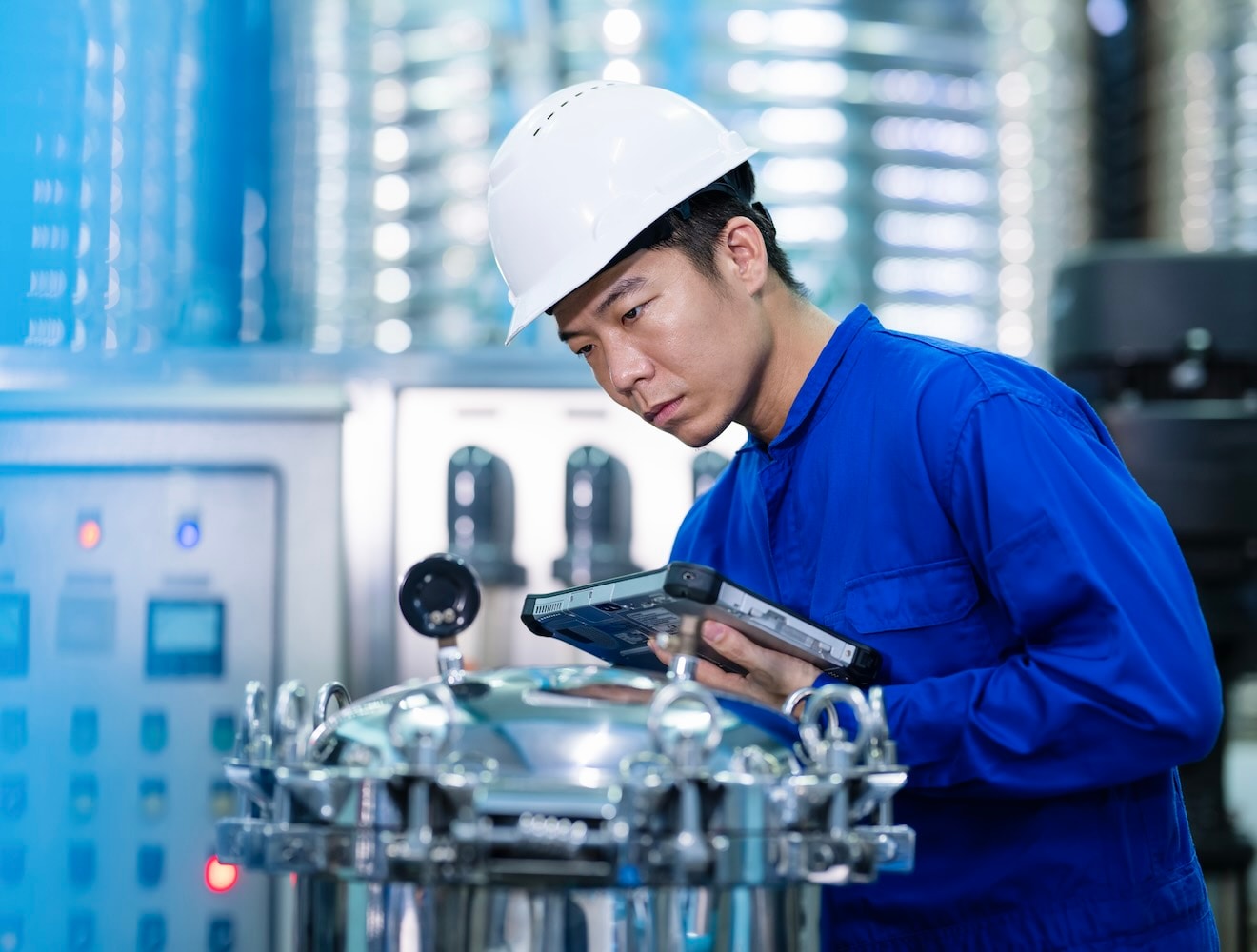 A worker inspects a water filter system in a treatment plant.