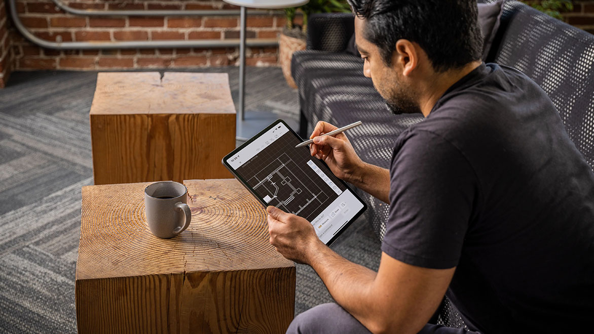 People using AutoCAD in a home office environment.