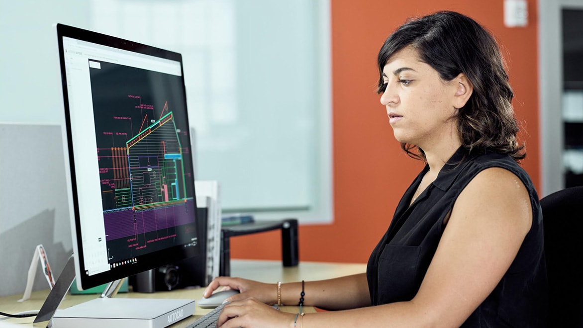 Woman using AutoCAD in a office environment.