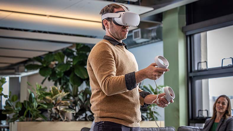 Man uses VR headset in office.