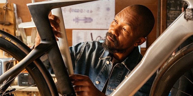 A bicycle designer works on an electric bike in a studio.
