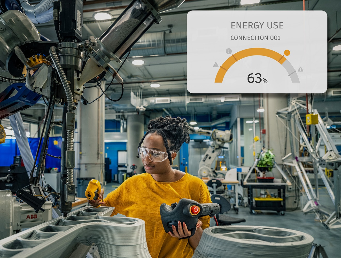 Engineer monitoring robotic manufacturing and energy use in a smart factory.