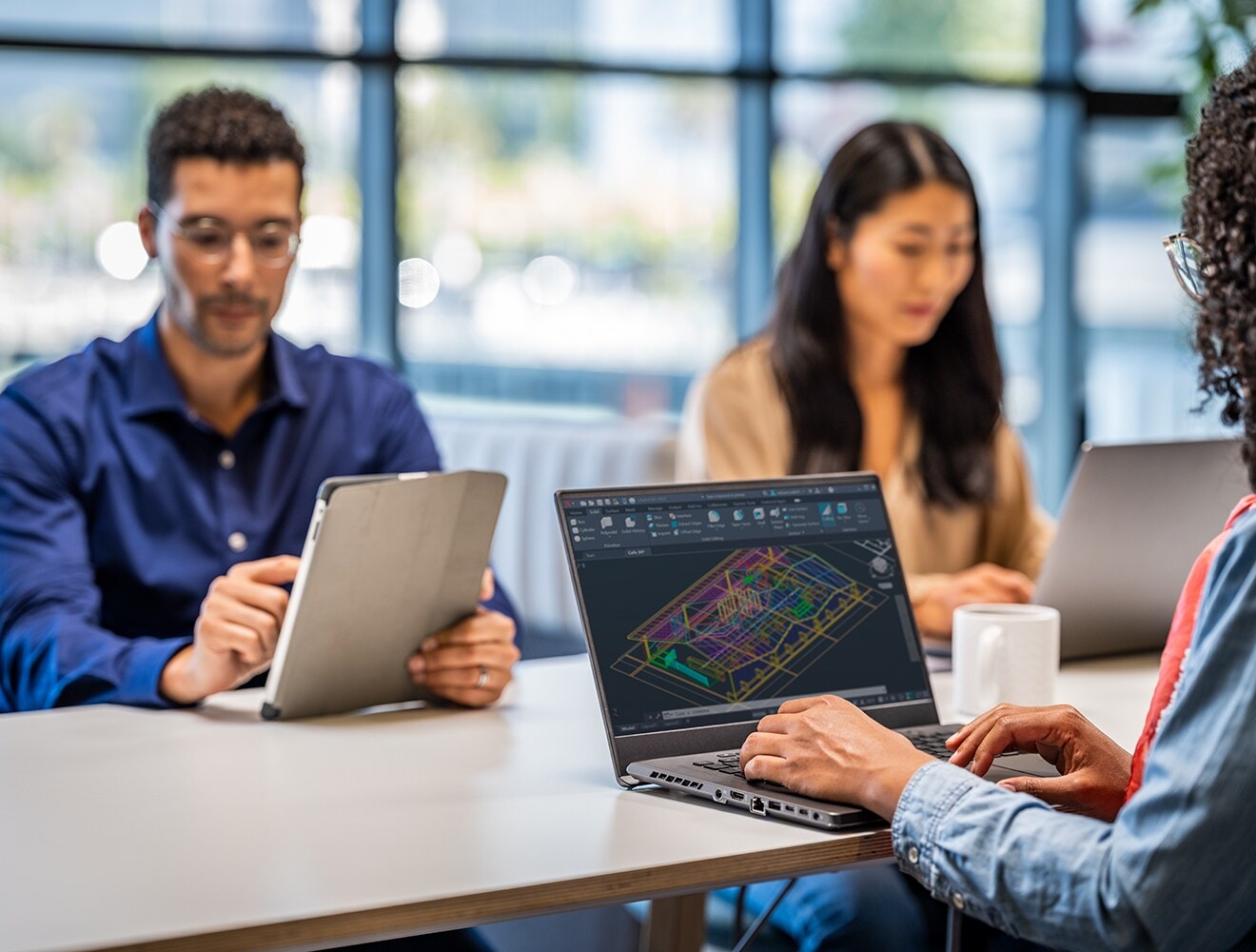 Person reviewing BIM model on laptop while sitting in a meeting