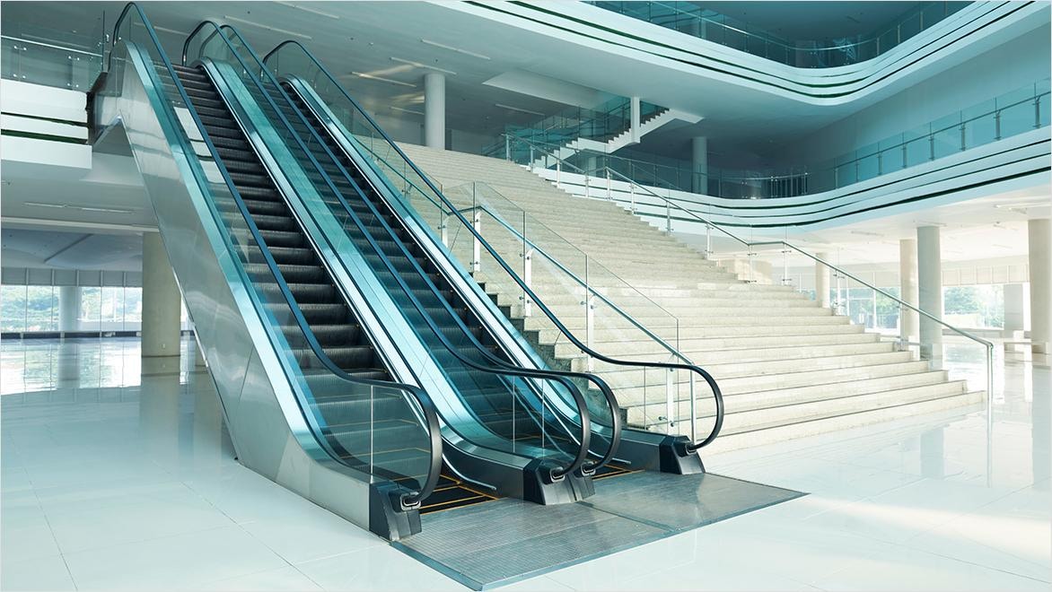 Interior of commercial building with tall escalator and wide staircase