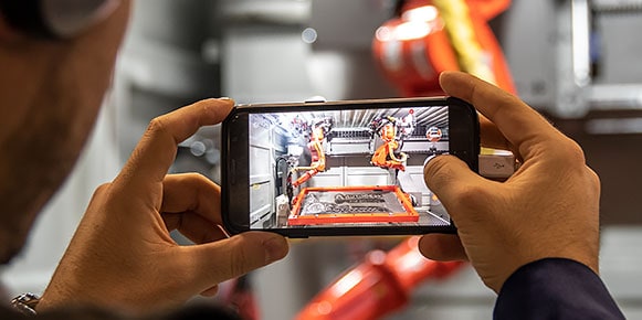 Attendee taking a photo of technology exhibit in the Expo Hall at Autodesk University 2018 in Las Vegas, Nevada. 