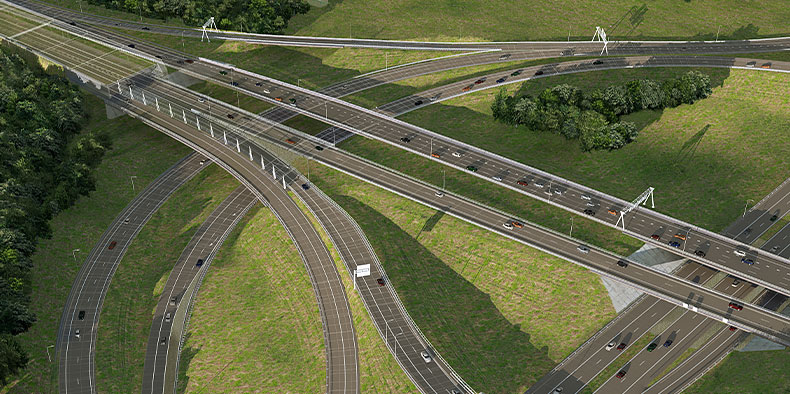 A birds-eye view of multiple connected highways and cars surrounded by green grass and trees