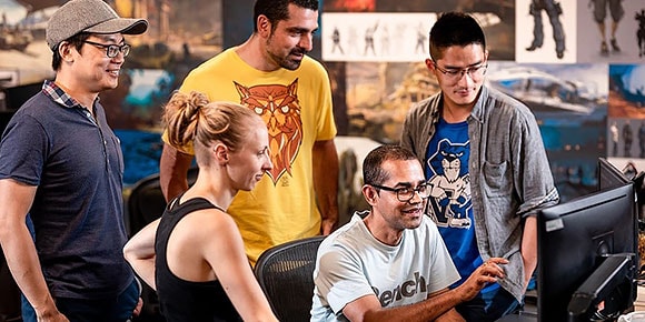 Teamgenoten kijken met een glimlach naar computer op kantoor