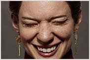 Une femme riant avec les yeux fermés