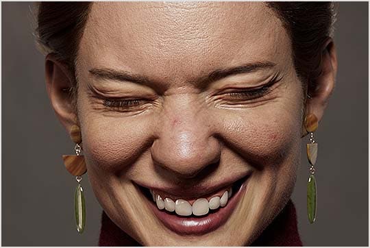 Woman laughing with her eyes closed