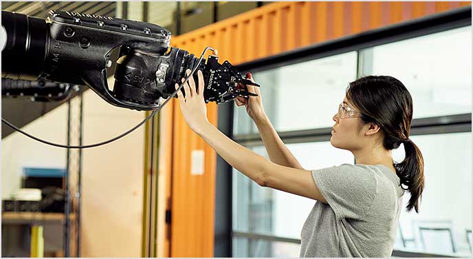 Žena pracující s aplikací AutoCAD a robotem