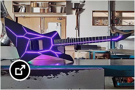 Custom guitar with bright, neon purple geometric lines